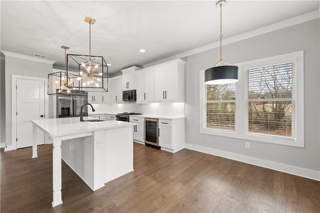 kitchen featuring beverage cooler, gas stove, stainless steel fridge with ice dispenser, a sink, and black microwave