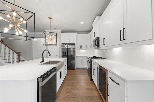 kitchen featuring range with gas stovetop, dishwashing machine, an inviting chandelier, stainless steel refrigerator with ice dispenser, and black microwave