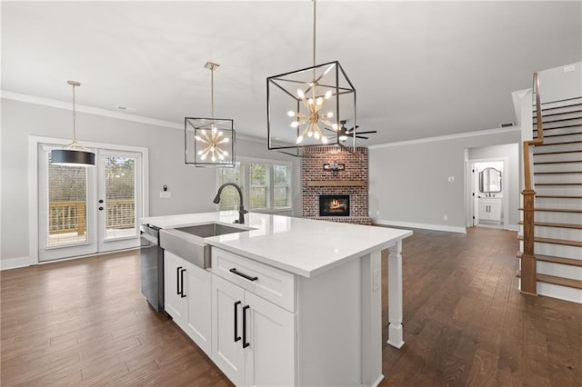 kitchen featuring dark wood-style flooring, ornamental molding, a sink, stainless steel dishwasher, and open floor plan