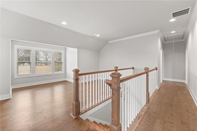 hall featuring visible vents, an upstairs landing, wood finished floors, baseboards, and attic access