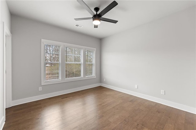 unfurnished room with baseboards, visible vents, and dark wood-style flooring