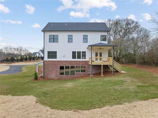 back of property featuring brick siding, a lawn, and stairs