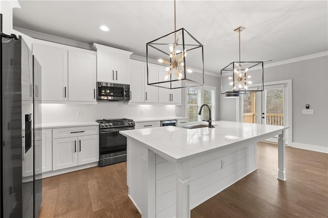 kitchen featuring a sink, appliances with stainless steel finishes, ornamental molding, and light countertops