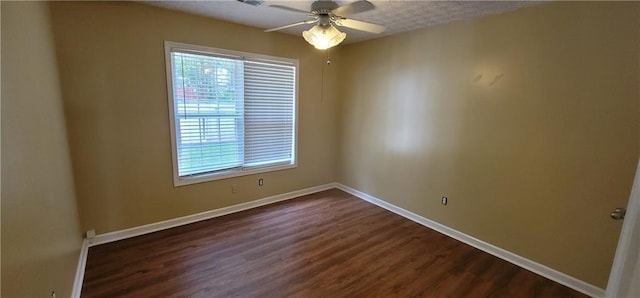 empty room with dark wood finished floors, baseboards, and ceiling fan