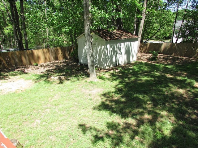 view of yard featuring a fenced backyard, an outdoor structure, and a storage shed
