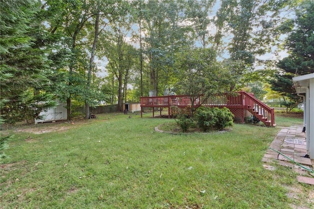 view of yard with an outbuilding, stairway, a wooden deck, and a shed