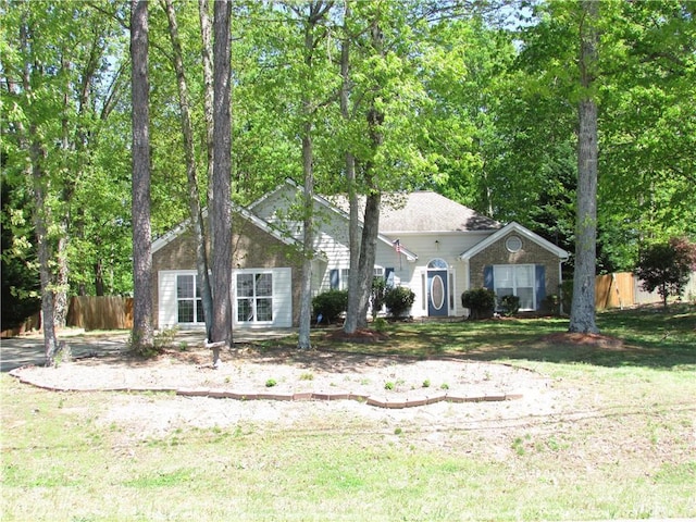 view of front of home with fence and a front lawn