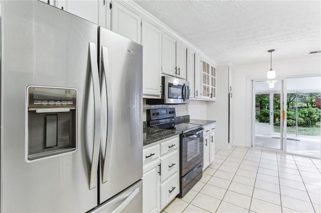 kitchen with a textured ceiling, white cabinetry, light tile patterned floors, glass insert cabinets, and appliances with stainless steel finishes