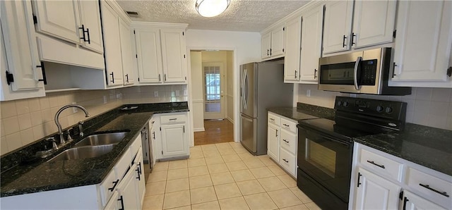 kitchen with a sink, stainless steel appliances, light tile patterned flooring, visible vents, and white cabinets