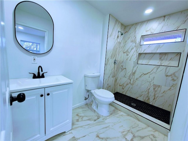 bathroom featuring tiled shower, vanity, and toilet