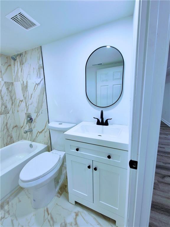 full bathroom featuring shower / tub combination, vanity, and toilet