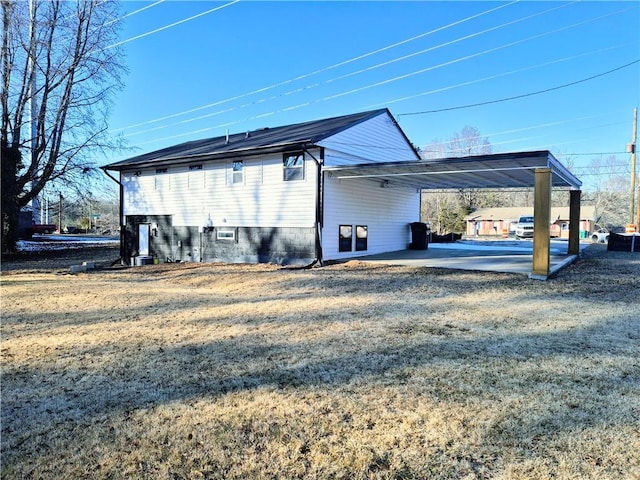 view of side of property featuring a carport and a lawn