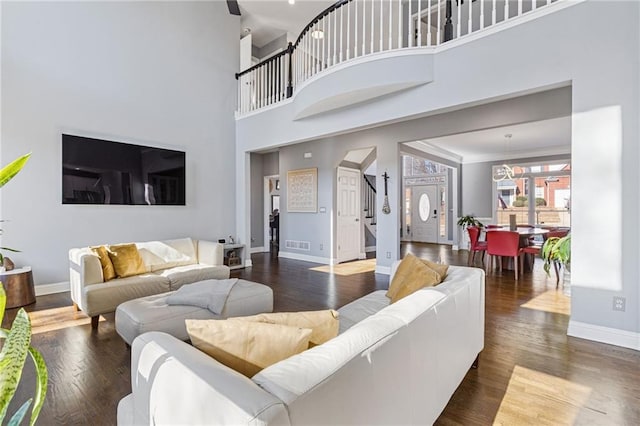 living room featuring dark wood-type flooring and a towering ceiling