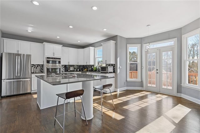 kitchen featuring white cabinetry, appliances with stainless steel finishes, a breakfast bar, and a kitchen island