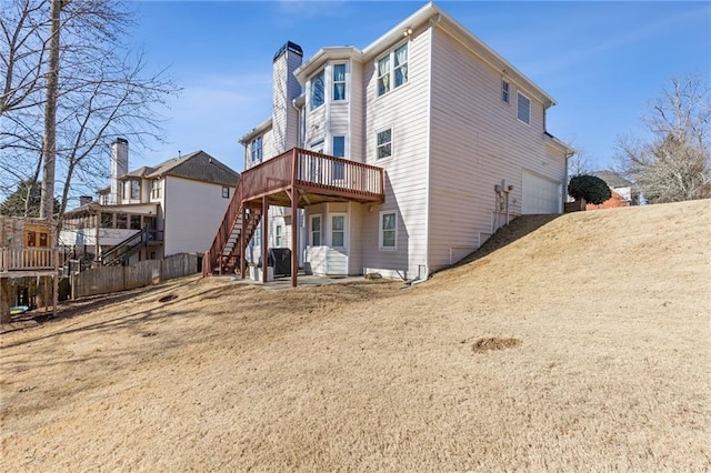 rear view of property featuring a garage and a deck