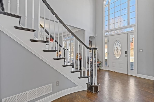 entrance foyer featuring a towering ceiling and dark hardwood / wood-style flooring