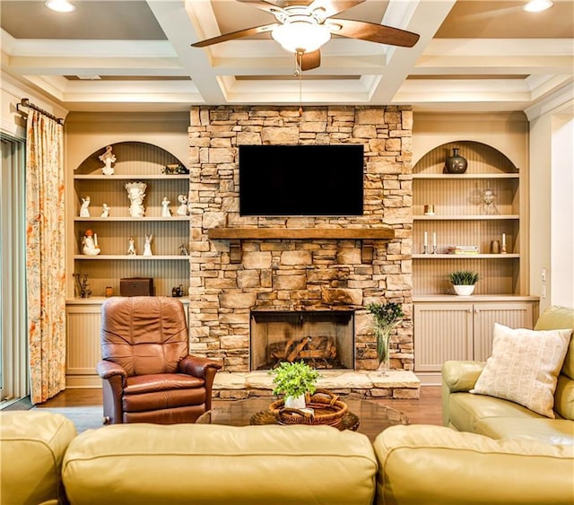 living room featuring beam ceiling, a stone fireplace, and coffered ceiling