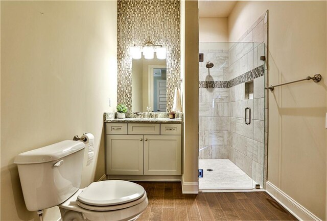 bathroom featuring toilet, vanity, and walk in shower