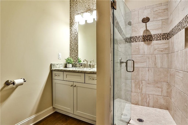 bathroom featuring vanity, hardwood / wood-style flooring, and a shower with shower door