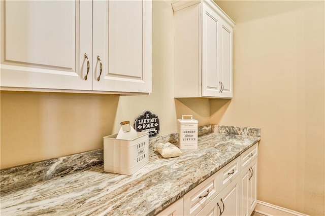 kitchen featuring white cabinetry and light stone countertops