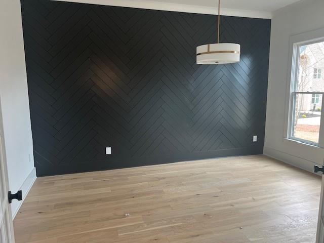 unfurnished room featuring baseboards and light wood finished floors