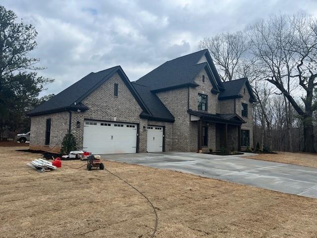 view of front facade featuring a garage, concrete driveway, and brick siding