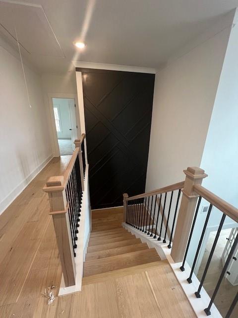 staircase featuring wood finished floors and baseboards