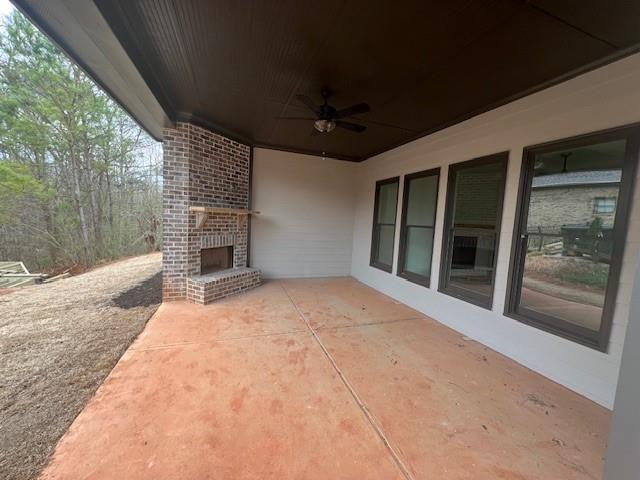 view of patio / terrace featuring ceiling fan and an outdoor brick fireplace