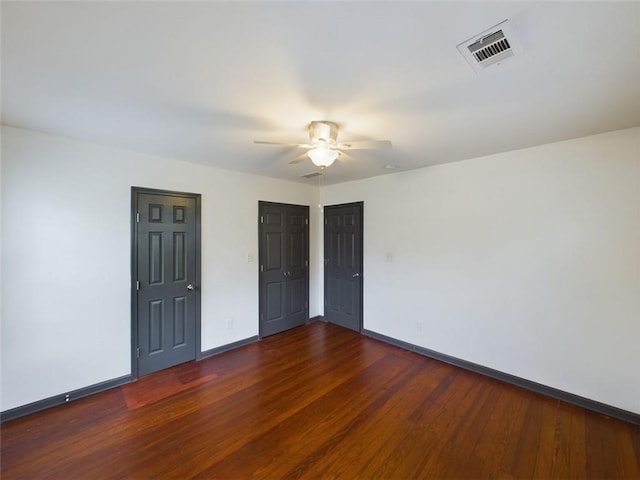 interior space with dark wood-type flooring and ceiling fan