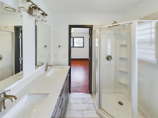 bathroom with a shower with shower door, hardwood / wood-style floors, and vanity