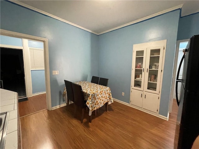 dining area with hardwood / wood-style flooring and ornamental molding