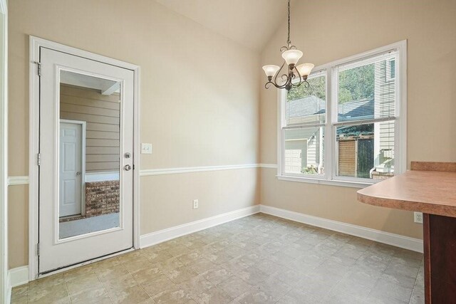 unfurnished dining area with a notable chandelier and lofted ceiling