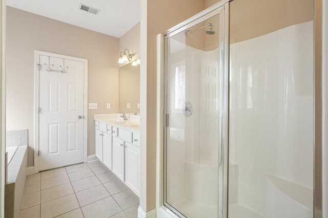 bathroom with plus walk in shower, vanity, and tile patterned flooring