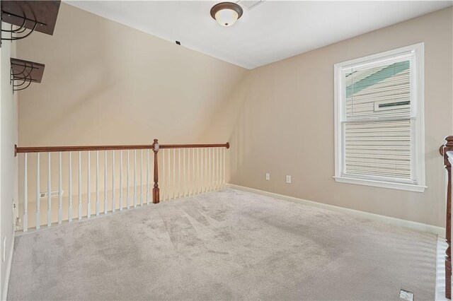 spare room with carpet flooring and lofted ceiling