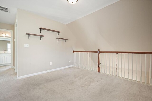 carpeted spare room with sink and lofted ceiling