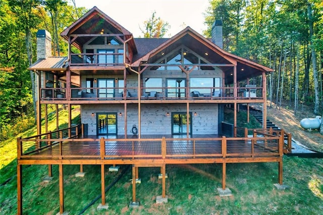 rear view of property featuring a deck and a chimney