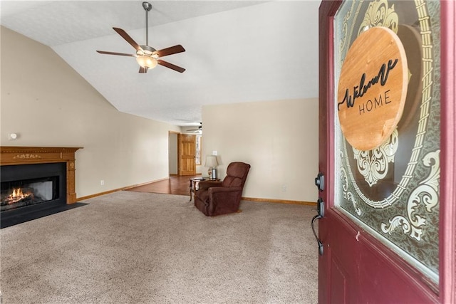 carpeted foyer with a fireplace with flush hearth, baseboards, a ceiling fan, and vaulted ceiling