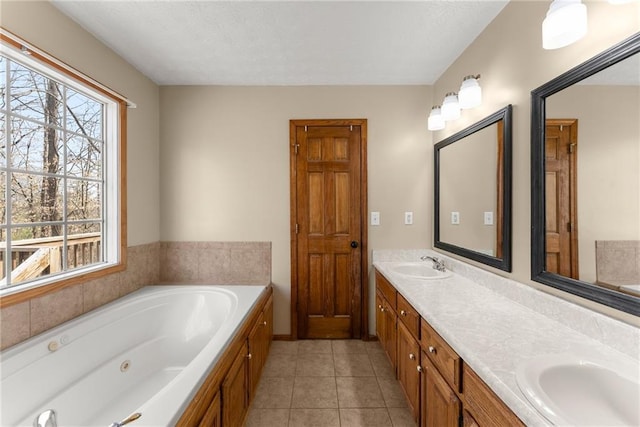 full bathroom with double vanity, a whirlpool tub, tile patterned floors, a textured ceiling, and a sink