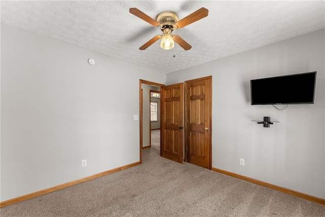 unfurnished bedroom featuring carpet, baseboards, and a textured ceiling