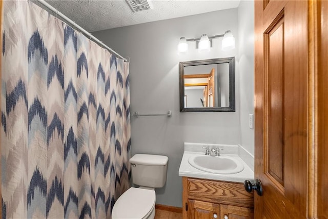 full bathroom featuring visible vents, toilet, curtained shower, a textured ceiling, and vanity