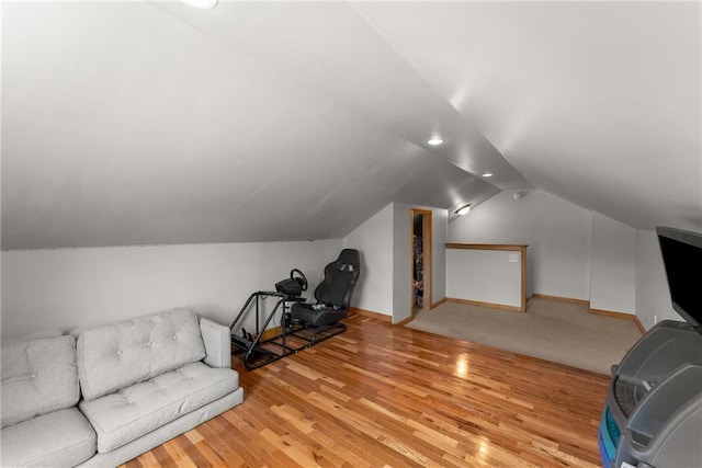 interior space with baseboards, lofted ceiling, and wood finished floors