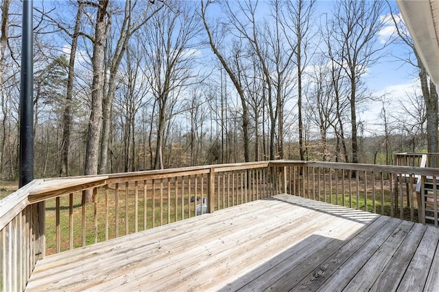 wooden terrace featuring a view of trees