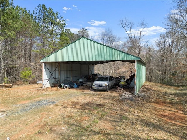 view of pole building featuring a detached carport and driveway