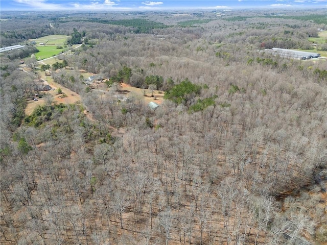 birds eye view of property featuring a forest view