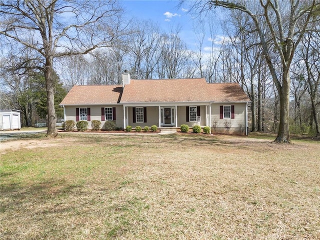 single story home featuring a chimney, a front yard, and a shingled roof