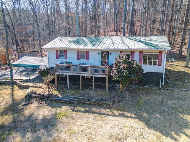 view of front of house with metal roof, dirt driveway, stairway, and a wooden deck