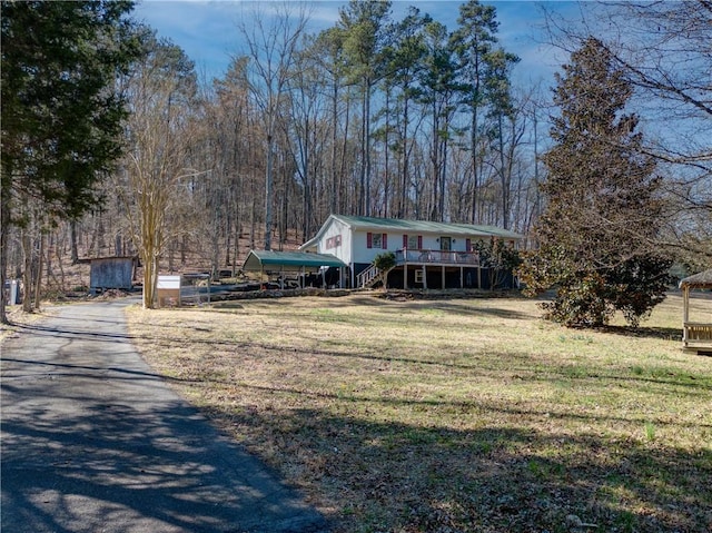 view of front facade featuring a front yard, a wooden deck, and stairs