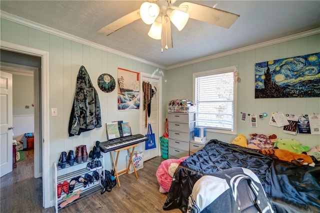 bedroom featuring ornamental molding, a ceiling fan, and wood finished floors