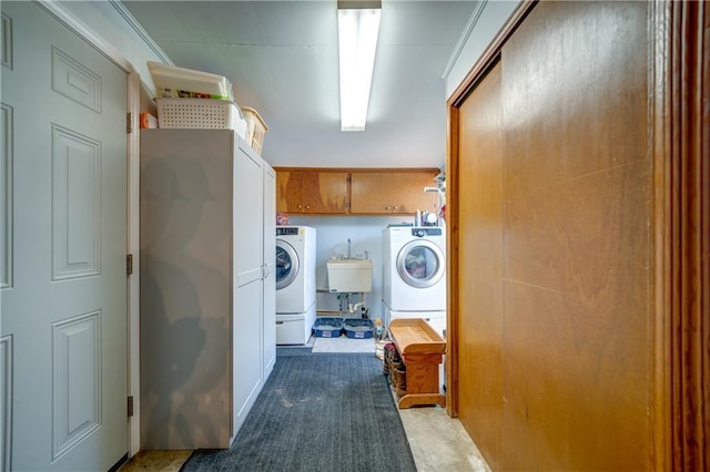 laundry room featuring cabinet space, a sink, and washing machine and clothes dryer