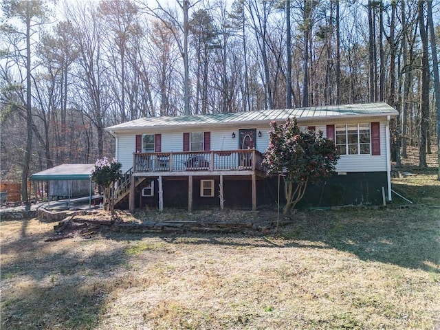 view of front of home with a detached carport, metal roof, a deck, and stairs